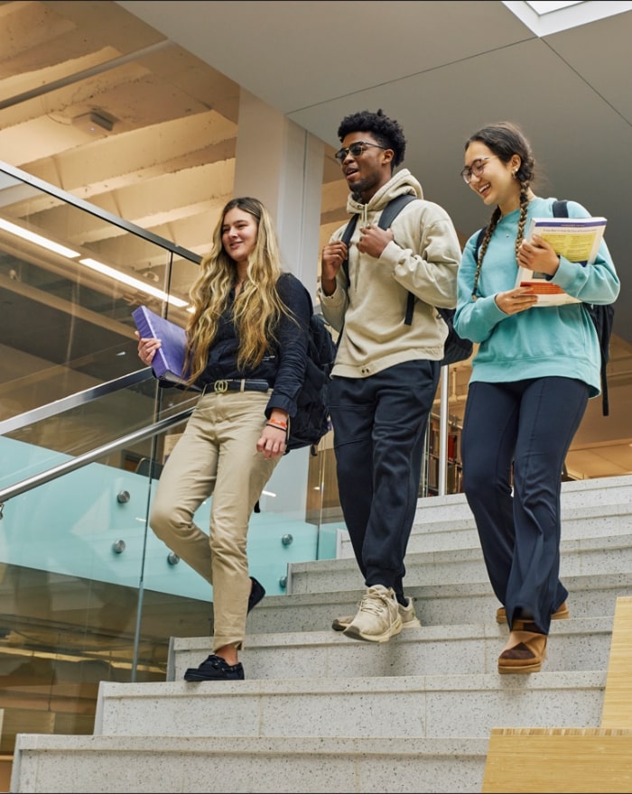 Three students walking downstairs at the library at MGA's Macon campus